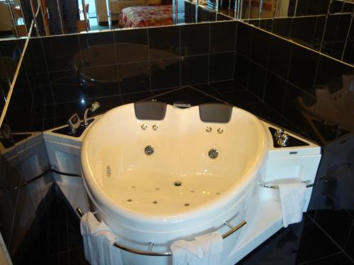 een bad in een zwart betegelde badkamer bij Grand Rapids Inn in Grand Rapids
