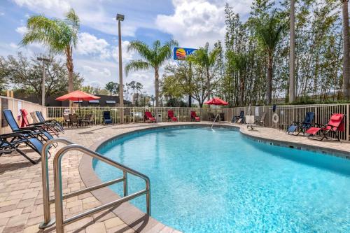 a swimming pool with chairs and umbrellas at a resort at Comfort Inn & Suites Orlando North in Sanford