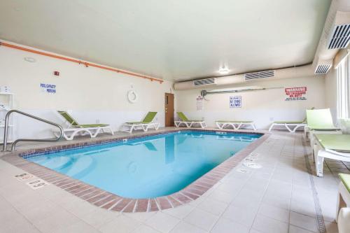 a pool in a hotel room with chairs and a table at Quality Inn & Suites Omaha Chalco in Omaha