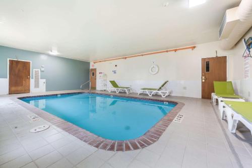 a large swimming pool in a room with chairs at Quality Inn & Suites Omaha Chalco in Omaha