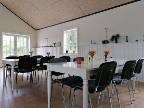 ビルンにあるAagaardenの白いテーブルと黒い椅子が備わる広い客室です。