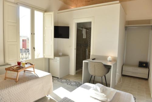 a bedroom with two beds and a desk and a window at Tobacco Suite in Mesagne