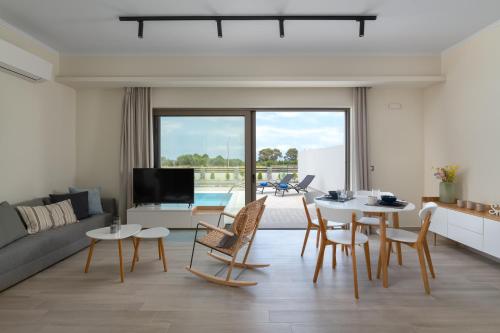 a living room with a couch and a table and chairs at Armonia Suites in Gennadi
