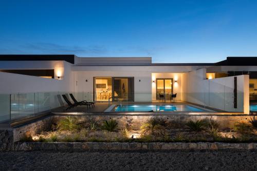 a house with a swimming pool at night at Armonia Suites in Gennadi