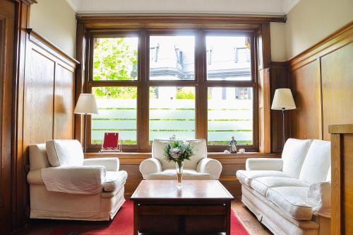 a living room with two chairs and a table at Hotel Neguri in Getxo