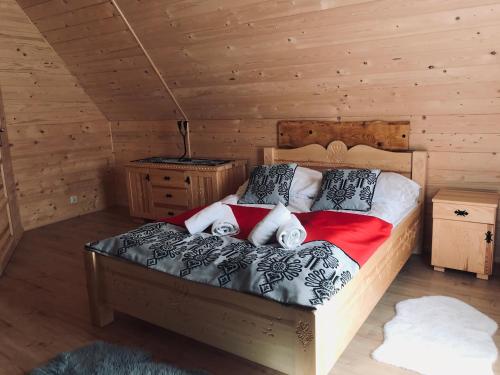 a bedroom with a bed in a log cabin at Domki Góralskie Hawrań i Murań in Bukowina Tatrzańska