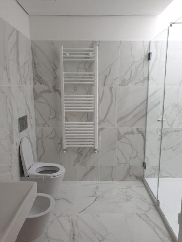 a white bathroom with a toilet and a shower at Casa das Hortênsias in Alijó