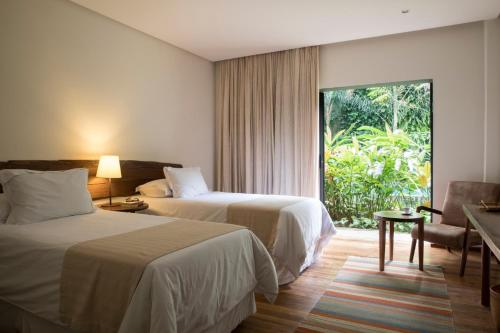 a hotel room with two beds and a window at Hotel Villa Amazônia in Manaus