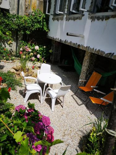 a patio with a table and chairs and flowers at Pensión Santa Rosa in Samos