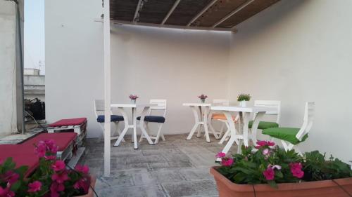 レヴェラーノにあるB&B la Coccinellaの白いテーブルと椅子、花が飾られた部屋