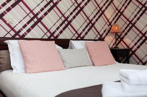 a bedroom with a bed with pink and white pillows at Boutique B&B The Townhouse in Bruges
