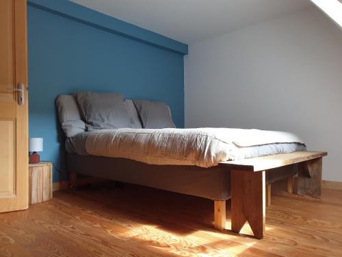 Cama en habitación con pared azul en LESPONNE Gîte Il granaio di Lesponne, en Lesponne