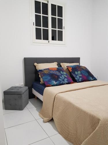 1 dormitorio con cama, banco y ventana en THE ISLAND PARADISE en Baillif