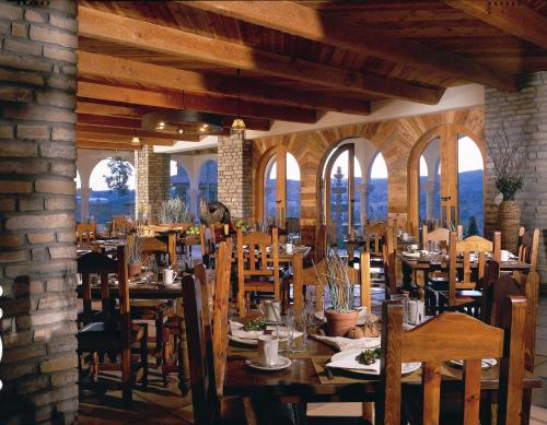a dining room with tables and chairs and windows at Lajitas Golf Resort in Terlingua