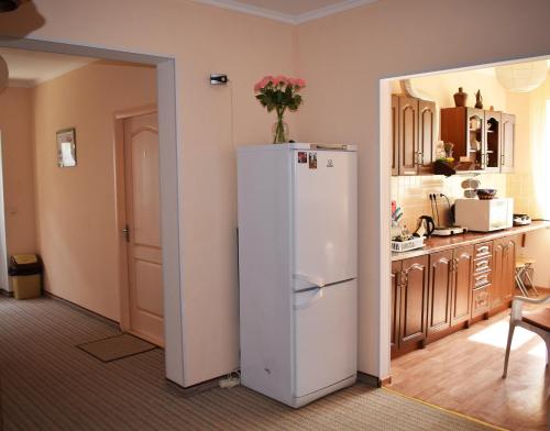 a kitchen with a white refrigerator in a room at Meraba Guest House in Bakhchysarai