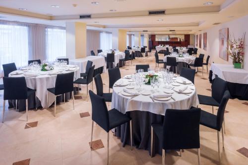 a banquet hall with white tables and chairs at Gran Hotel Rey Don Jaime in Castelldefels