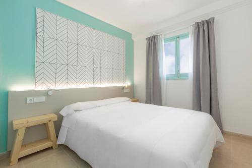 En eller flere senge i et værelse på Apartamentos Los Arcos