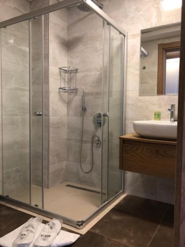阿拉恰特的住宿－Neva Hotel Alaçatı，一间带玻璃淋浴间和水槽的浴室