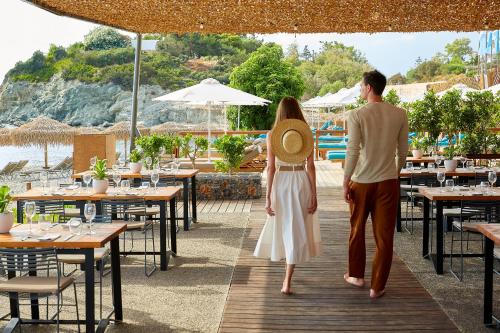 a man and a woman walking down a wooden walkway at Vincci EverEden in Anavissos