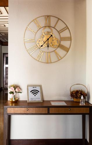 a large clock on a wall above a wooden table at Hotel Santa Cecília in Fátima