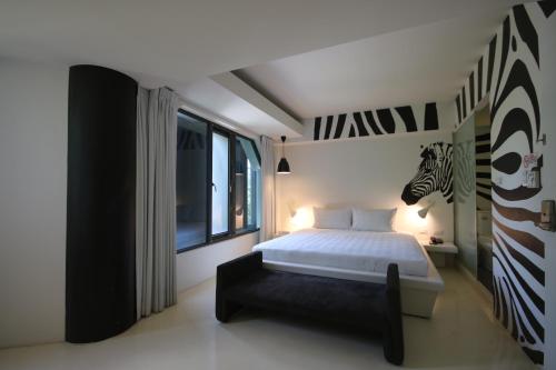 a bedroom with a bed with a zebra picture on the wall at Hotel Papa Whale-Kaohsiung Formosa Boulevard in Kaohsiung