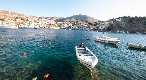 a white boat in a body of water at Odyssia in Symi