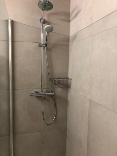 een douche met een douchekop in een badkamer bij Appartement Belle Mer - Adults Only in Middelkerke