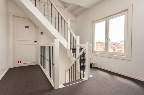 a white staircase with a white door and a window at Boutique B&B The Townhouse in Bruges