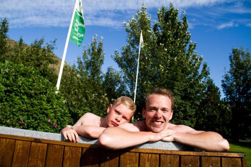 a man and a child in a bath tub at Ásólfsskáli Cottage in Ásólfsskáli