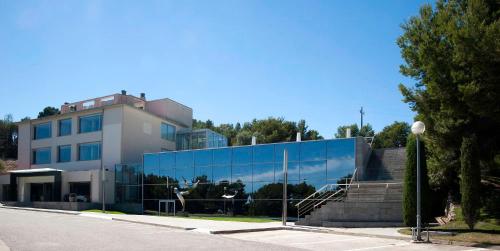 a building with a glass facade on a street at Gran Hotel Rey Don Jaime in Castelldefels