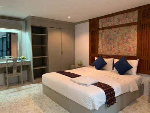 a bedroom with a large bed and a desk at Blue Garden Resort Pattaya in Jomtien Beach