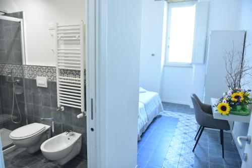 a bathroom with a toilet and a sink and a tub at Tobacco Suite in Mesagne