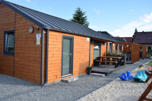 una cabina in legno con panchina e tavolo da picnic di DOMKI WYPOCZYNKOWE ZOSIA I HELENKA a Puck