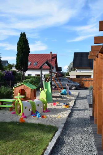 un parque infantil en un patio con un equipo de juegos para niños en DOMKI WYPOCZYNKOWE ZOSIA I HELENKA, en Puck