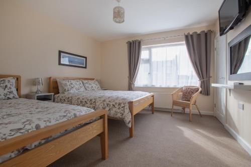 A bed or beds in a room at Roedean Guest House 