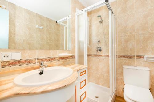 a bathroom with a sink and a shower and a toilet at Apartamentos Los Arcos in Santa Eularia des Riu
