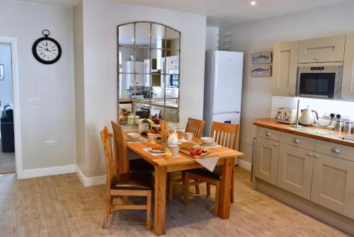 uma cozinha com uma mesa de madeira com cadeiras e um balcão em Ironmasters House em Ironbridge