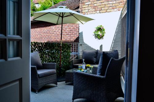 une terrasse avec des chaises et une table avec un parasol dans l'établissement Ironmasters House, à Ironbridge