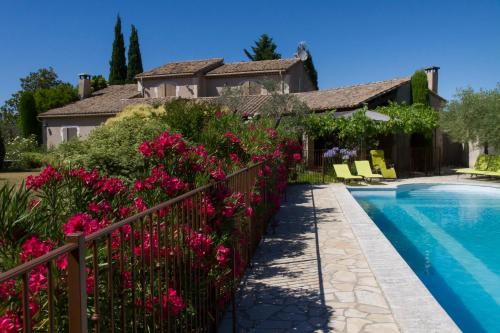 une maison avec piscine et fleurs roses dans l'établissement Maison de campagne au charme provençal, à Saint-Rémy-de-Provence