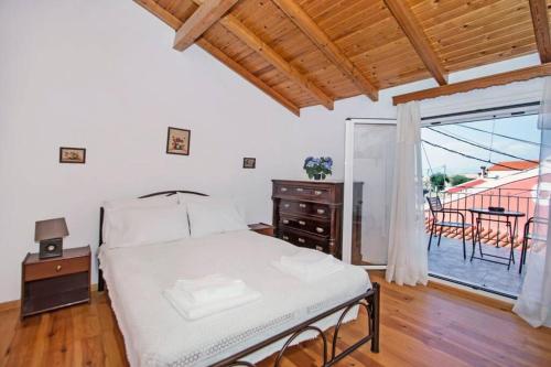 - une chambre avec un lit et un balcon avec une table dans l'établissement Spiti Maria, à Valaneíon