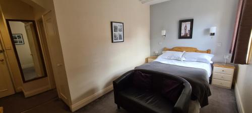 a bedroom with a bed and a chair in it at The Merton Hotel in Hereford