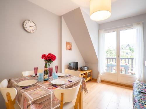 une salle à manger avec une table et une horloge au mur dans l'établissement Apartment Fleur Marine-13 by Interhome, à Cabourg