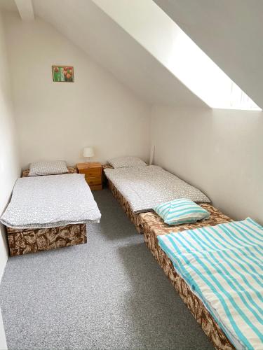 a room with two beds in a room at Penzion Hřensko in Hřensko