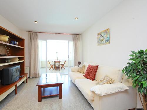 ein Wohnzimmer mit einem weißen Sofa und einem Fernseher in der Unterkunft Apartment Cabo Mar by Interhome in El Campello