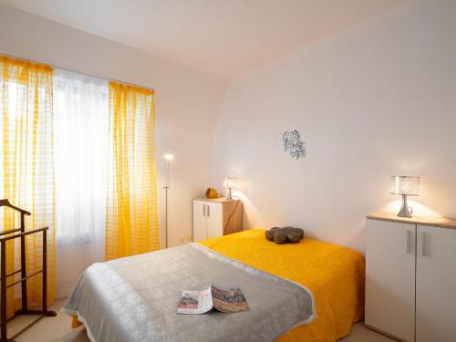 um quarto com uma cama amarela e uma janela em Apartment Le Viking by Interhome em Cabourg