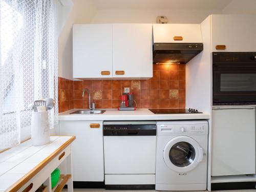 une cuisine avec des armoires blanches et une laveuse et une sécheuse dans l'établissement Apartment Le Viking by Interhome, à Cabourg