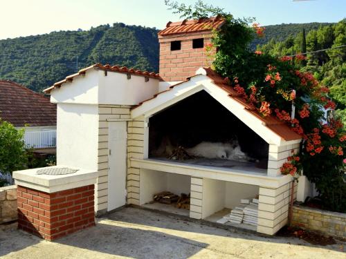 una casa de perros con chimenea en el patio trasero en Holiday Home Lolita by Interhome, en Račišće