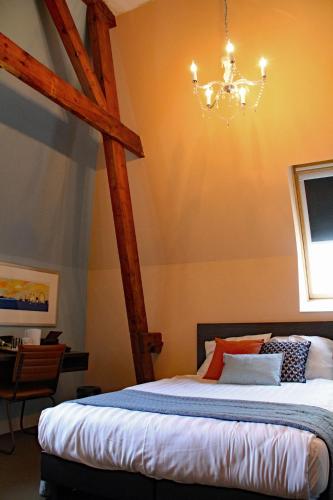 a bedroom with a bed and a chandelier at Hotel De Villa in Dongen