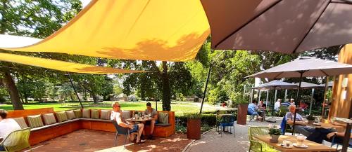 a group of people sitting at tables under umbrellas at Hotel De Villa in Dongen