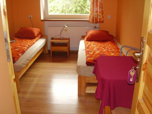 a room with two beds and a table and a window at Dom Wypoczynkowy POD FORTAMI in Srebrna Góra